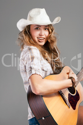 Sesy cowgirl in cowboy hat with acoustic guitar