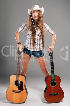 Sesy cowgirl in cowboy hat with acoustic guitar