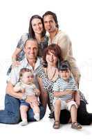 Studio Shot Of Family Group Sitting In Studio