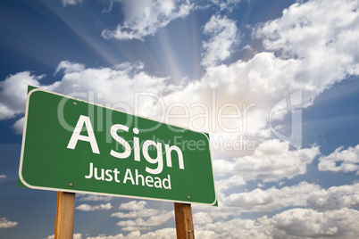 A Sign Green Road Sign Against Clouds