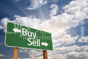 Buy, Sell Green Road Sign Against Clouds