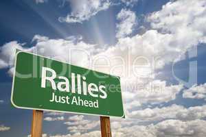 Rallies Green Road Sign Against Clouds