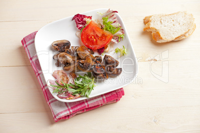 marinierten Champignons und etwas Salat in einer Schüssel