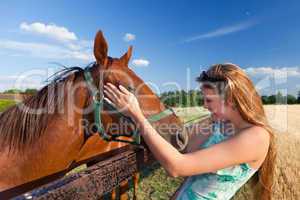 horse and blond girl in paddock on summers