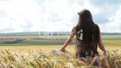 young woman standing in wheat field