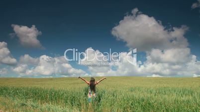 Woman in Wheat Field With Arms Outstretched