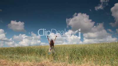 Woman in Wheat Field With Arms Outstretched
