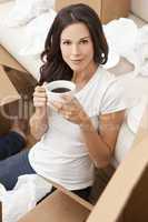 Single Woman Drinking Tea or Coffee Unpacking Boxes Moving House