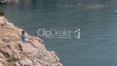 young woman resting on the cliff