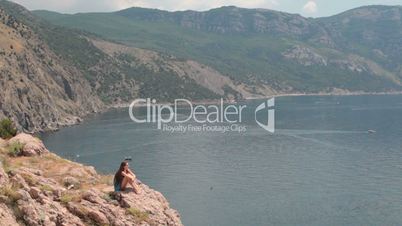 young woman Resting on  cliff near the Black Sea