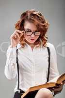 young woman in glasses with a book