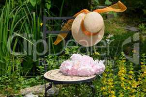 Stuhl Hut und Blumen im Garten