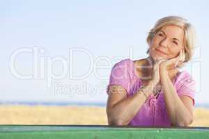 Thoughtful Attractive Senior Woman Sitting Outside at Table