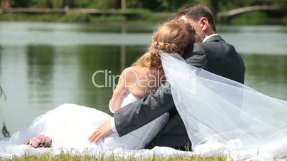 newlyweds embracing on  shore of Lake