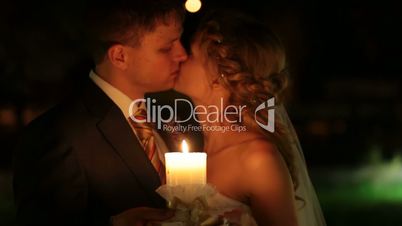 just married couple kissing by candlelight