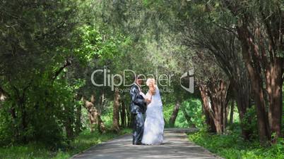 just married couple  hugging on  park alley