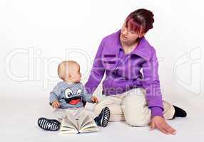 Kleinkind blättert im Buch und die Mutter sieht zu 153