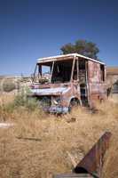 An old abandoned vintage delivery truck van in a field