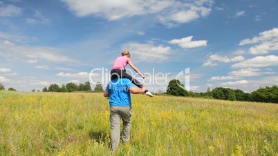 Girl ride the father in the summer field