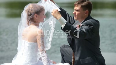 groom lifts veil from  face of  bride