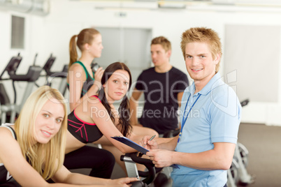 Young fitness instructor gym people spinning