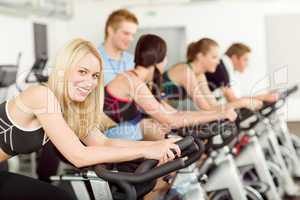 Young fitness people bike spinning with instructor