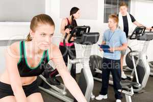 Young fitness woman doing spinning with instructor