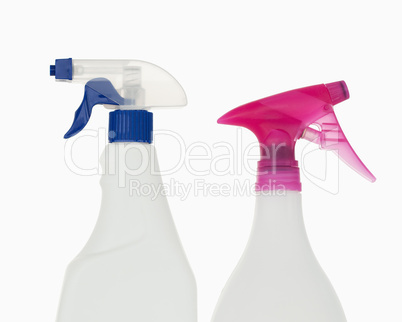 Close up of a pink and a blue spray bottles