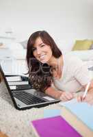 Young brunette woman relaxing with her laptop and posing while w