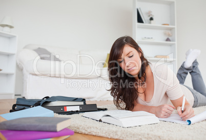 Young beautiful woman writing on a notebook while lying on a car