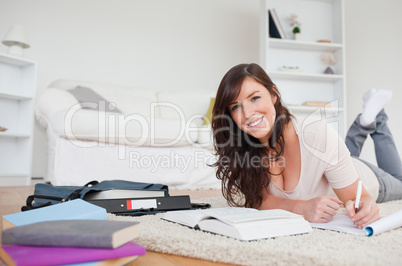 Young attractive woman writing on a notebook while lying on a ca