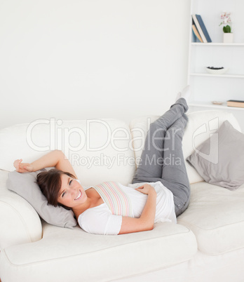 Gorgeous brunette female posing while lying on a sofa