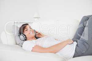 Good looking brunette female relaxing with her headphones while