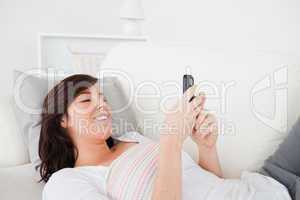 Good looking brunette female writing a text on her mobile