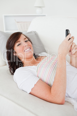 Beautiful brunette female writing a text on her mobile