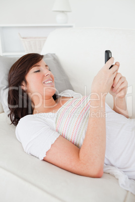 Pretty brunette female writing a text on her mobile