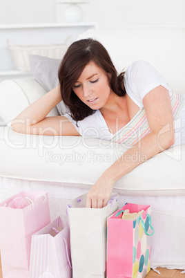Young attractive female posing with her shopping bags while lyin