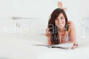 Pretty female reading a magazine while lying