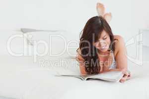 Cute female reading a magazine while lying