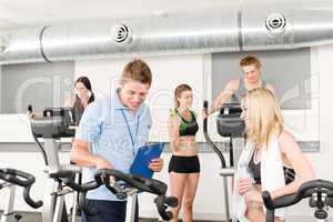 Young fitness instructor gym people spinning