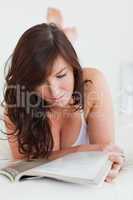 Good looking female reading a magazine while lying