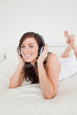 Beautiful female with headphones lying