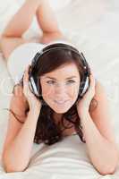 Attractive female with headphones lying