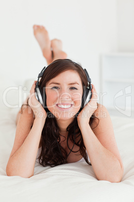 Pretty female with headphones lying