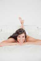 Smiling brunette woman posing while lying