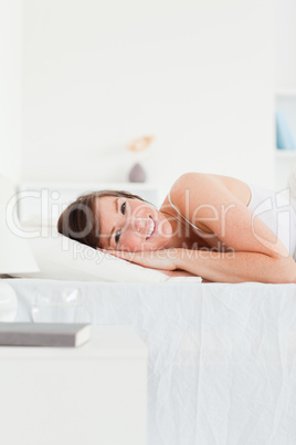 Happy brunette female posing while lying