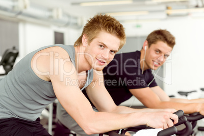 Fitness young man on gym bike spinning