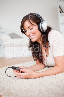 Pretty brunette woman listening to music with her mp3 player whi