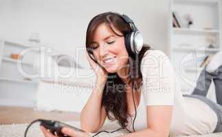 Cute brunette woman listening to music with her mp3 player while