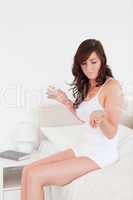 Beautiful brunette woman taking some pills while sitting